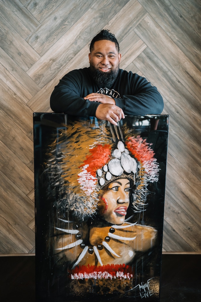 (Photo courtesy of Kara Schumacher) Artist Aljay Fuimaono poses in February 2019 with his first “live painting” for Pasifika First Fridays. The painting is part of the festival's collection.