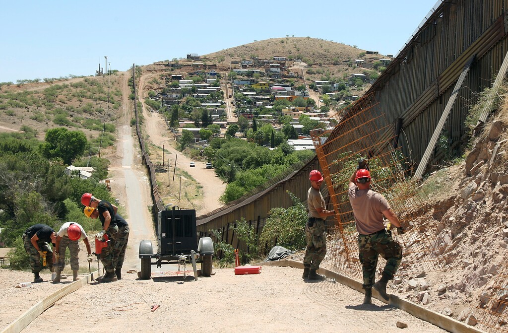 (Ross D. Franklin | The Associated Press) In this June 20, 2008 file photo, members of the 200th Red Horse Air National Guard Civil Engineering Squadron from Camp Perry in Ohio, including Tech Sgt. David Hughes, right, and Tech Sgt. William Bunker, second from right, work on building a road at the border in Nogales, Ariz. President Donald Trump said April 3, 2018, he wants to use the military to secure the U.S.-Mexico border until his promised border wall is built. The Department of Homeland Security and White House did not immediately respond to requests for comment. At the Pentagon, officials were struggling to answer questions about the plan, including rudimentary details on whether it would involve National Guard members, as similar programs in the past have done. But officials appeared to be considering a model similar to a 2006 operation in which former President George W. Bush deployed National Guard troops to the southern border in an effort to increase security and surveillance.