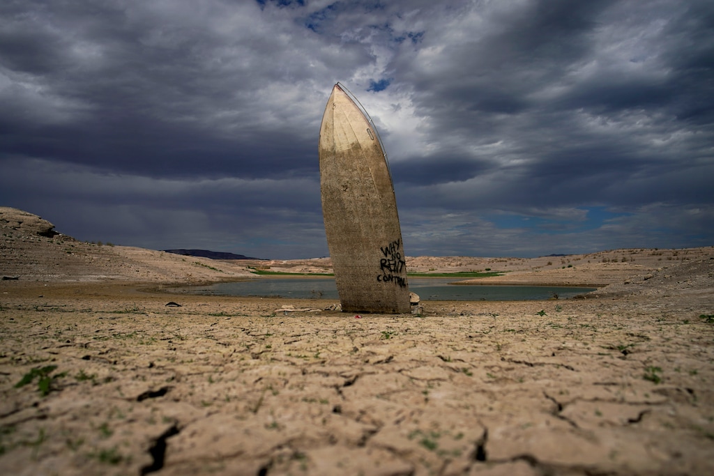 (John Locher | AP) A formerly sunken boat stands upright into the air with its stern buried in the mud along the shoreline of Lake Mead at the Lake Mead National Recreation Area on June 22, 2022, near Boulder City, Nev. The U.S. Interior Department announced, Friday, Oct. 28, 2022, that it will consider revising a set of guidelines for operating two major dams on the Colorado River in the first sign of what could lead to federal action to protect the shrinking reservoirs behind them.