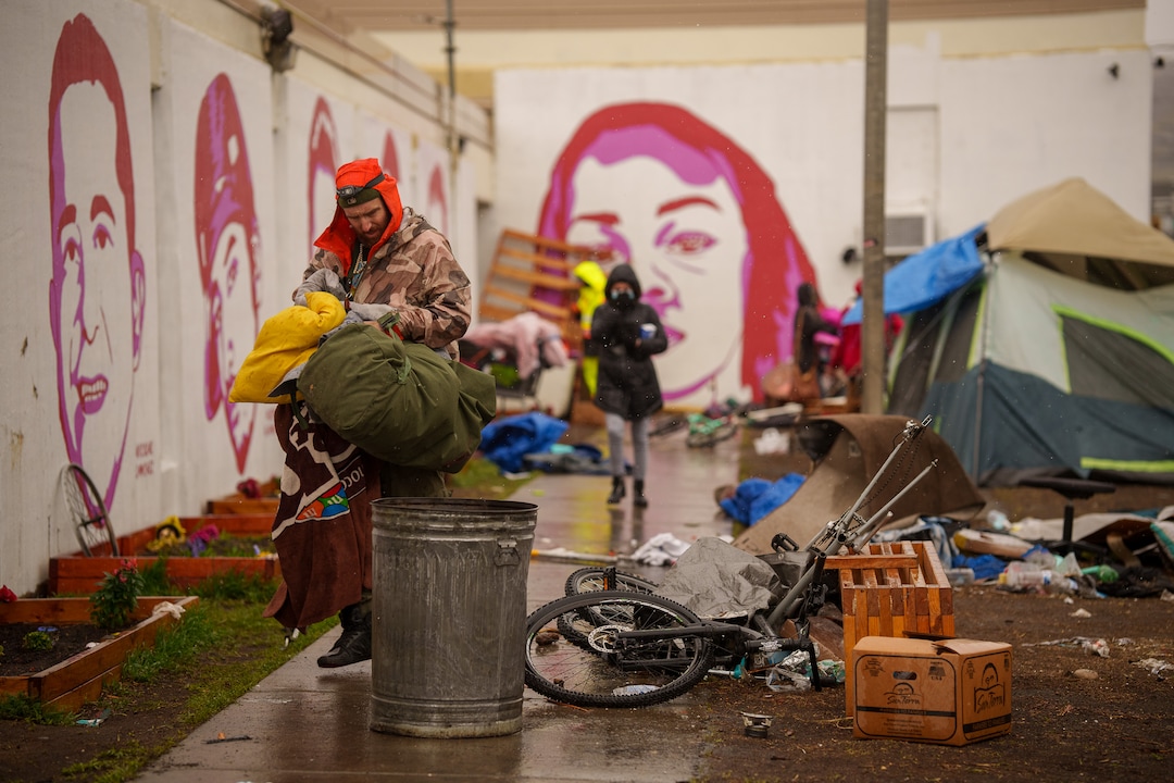 (Trent Nelson  |  The Salt Lake Tribune) People sort through their belongings as Salt Lake County conducts a camp cleanup at the Fleet Block Murals in Salt Lake City on Wednesday, April 14, 2021.