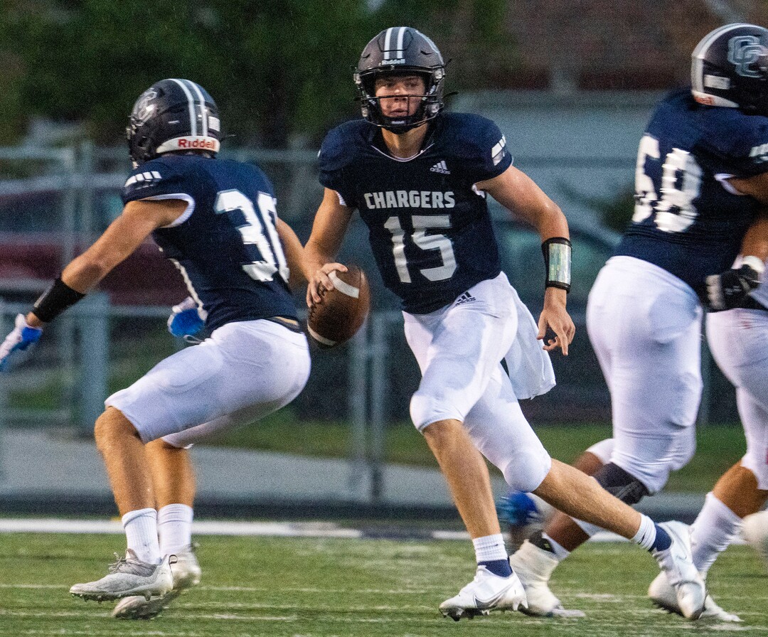 (Rick Egan | The Salt Lake Tribune) Corner Canyon quarterback Devin Brown (15), looks down field as he scrambles with the ball in prep football action between Corner Canyon Chargers and the East Leopards, on Saturday, Aug. 21, 2021.