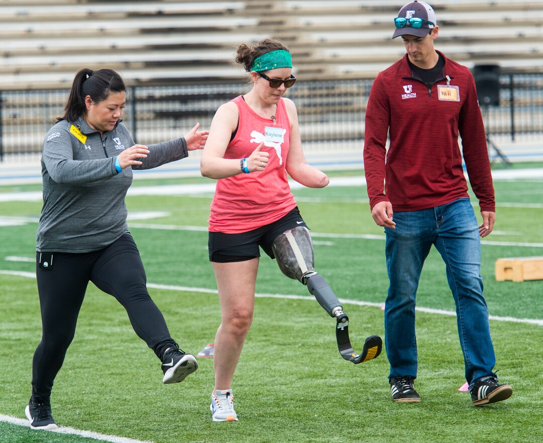 (Rick Egan  |  The Salt Lake Tribune)     Grace Ku helps Kaylene Baker, Helena, Mt, along with Will Cook, during the fourth annual Utah Adaptive Mobility Clinic at Skyline High school. The clinic allows anyone with "lower extremity limb loss or limb difference" or amputees without legs, to practice walking and running. Saturday, June 1, 2019.