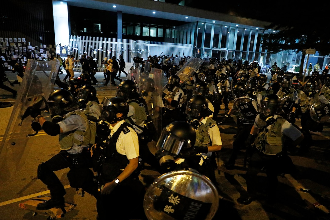 (Vincent Yu | AP Photo) Police officers in anti-riot gear clear protesters from the Legislative Council in Hong Kong, during the early hours of Tuesday, July 2, 2019.  Hundreds of protesters in Hong Kong swarmed into the legislature's main building Monday night, tearing down portraits of legislative leaders and spray-painting pro-democracy slogans on the walls of the main chamber as frustration over a lack of response from the administration to opposition demands boiled over.