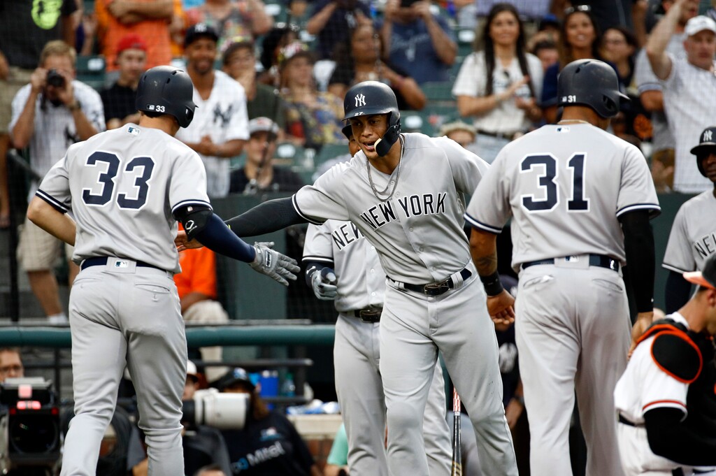 New York Yankees' Giancarlo Stanton, center, greets teammate Greg Bird after scoring on Bird's grand slam during the third inning against the Baltimore Orioles in a baseball game Wednesday, July 11, 2018, in Baltimore. (AP Photo/Patrick Semansky)