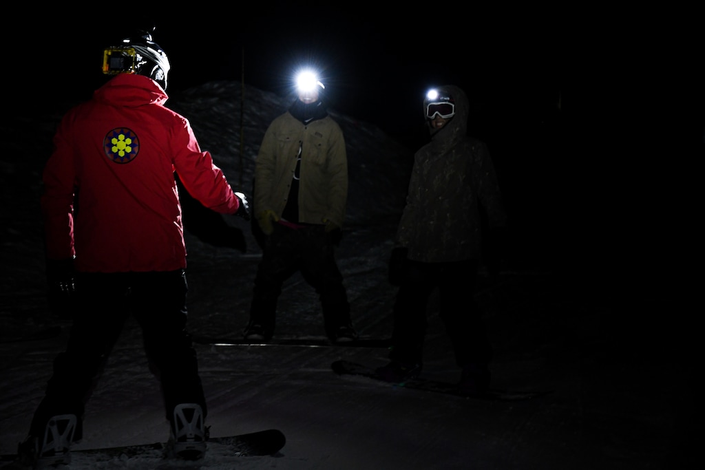 (Photo courtesy of Jovvany Villalobos | Brighton Resort)
Ski school guide Bill Novak discusses a game plan with snowboarders Chelsey Kim and Jack Gahlman. Brighton Resort offered headlamp skiing and snowboarding for the first time Friday, Feb. 21, 2020.