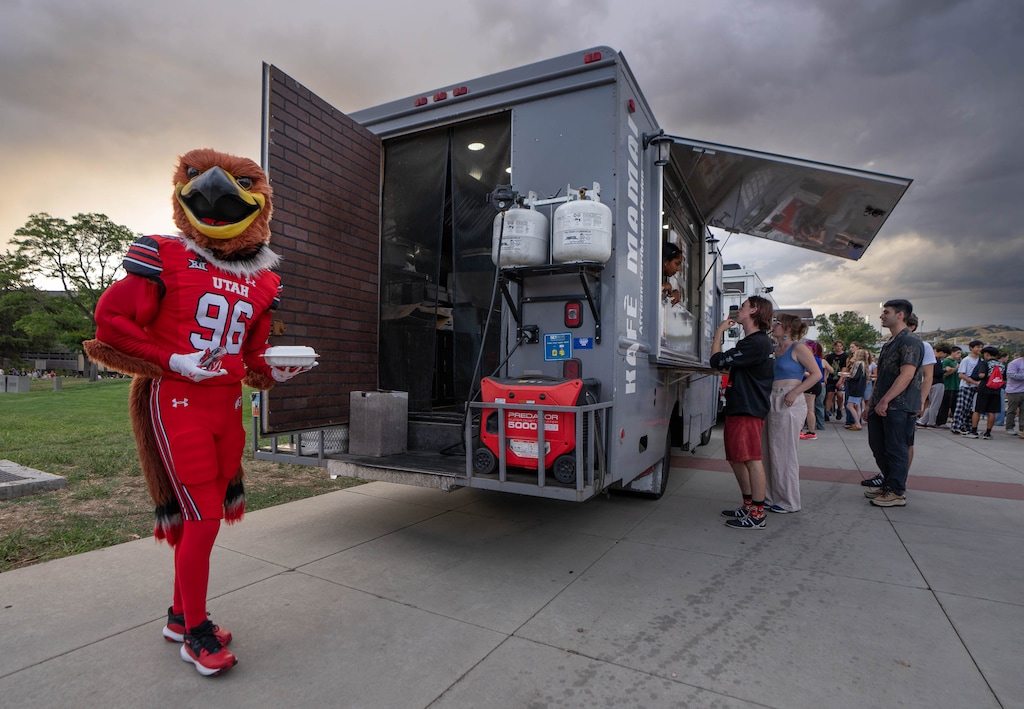 (Francisco Kjolseth | The Salt Lake Tribune) University of Utah mascot Swoop scores a plate of grilled jerk chicken from the Kafé Mamai food truck during a campus event on Saturday, Aug. 22. The U. is moving to a different food truck model, which has longtime vendors concerned.