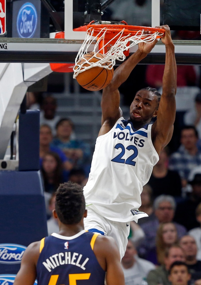 Minnesota Timberwolves' Andrew Wiggins (22) dunks as Utah Jazz's Donovan Mitchell looks on during the first half of an NBA basketball game Friday, Oct. 20, 2017, in Minneapolis. (AP Photo/Jim Mone)