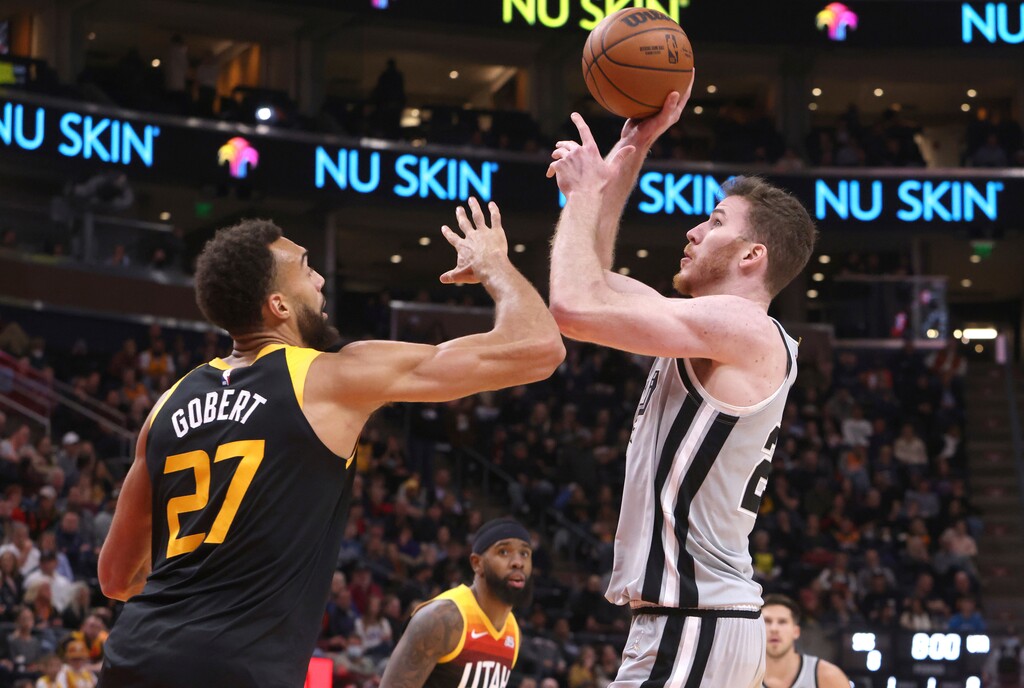 Utah Jazz center Rudy Gobert (27) defends against San Antonio Spurs center Jakob Poeltl, right, during the first half of an NBA basketball game on Friday, Dec. 17, 2021, in Salt Lake City. (AP Photo/Kim Raff)