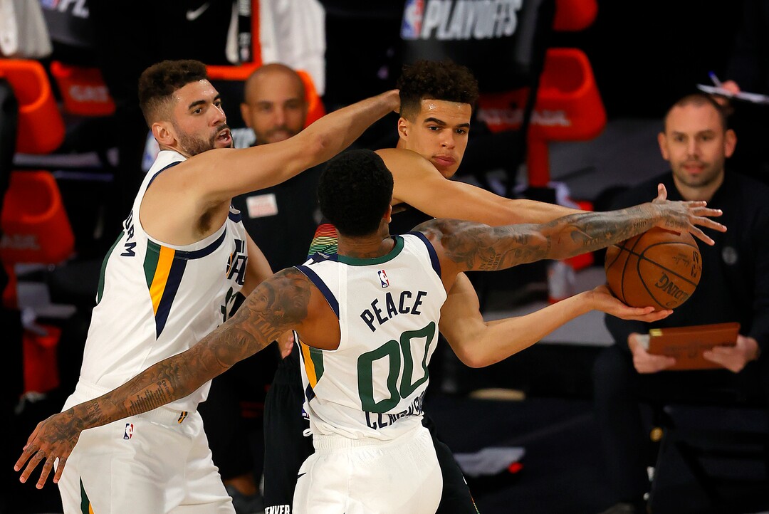 Michael Porter Jr., center, of the Denver Nuggets handles the ball as Utah Jazz defenders Georges Niang, left,  and Jordan Clarkson, right, defend during the second half of Game 5 of an NBA basketball first-round playoff series, Tuesday, Aug. 25, 2020, in Lake Buena Vista, Fla. (Mike Ehrmann/Pool Photo via AP)