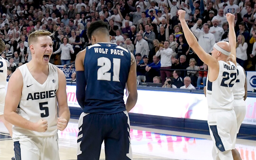 (Eli Lucero  |  The Herald Journal via AP) Utah State guard Sam Merrill (5) and guard Brock Miller (22) celebrate next to Nevada forward Jordan Brown (21) after Merrill drew a charge during an NCAA college basketball game Saturday, March 2, 2019, in Logan, Utah.