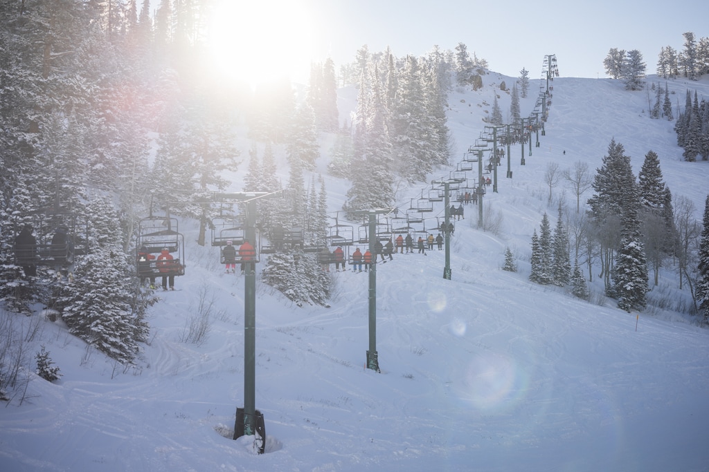 (Tristan Sadler | Powder Mountain) Skiers and snowboarders take a slow ride up the Timberline lift during opening weekend at Powder Mountain on Dec. 9, 2023. The resort plans to replace the lift with a fixed-grip quad for the 2024-25 season. The Paradise lift will also be upgraded and the resort will build two new lifts, one for the public up Lightning Ridge and another private lift for homeowners to Cobabe Canyon.