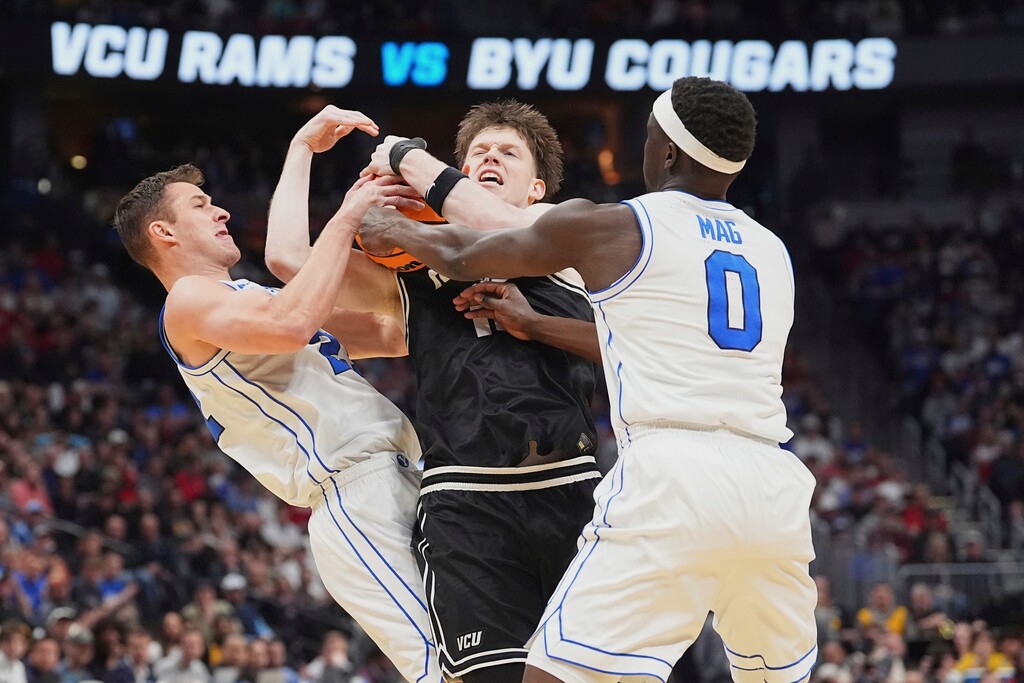 (David Zalubowski | AP) Virginia Commonwealth guard Max Shulga, center, fights for control of the ball with BYU guard Trevin Knell, left, and forward Mawot Mag during the first half in the first round of the NCAA college basketball tournament Thursday, March 20, 2025, in Denver.