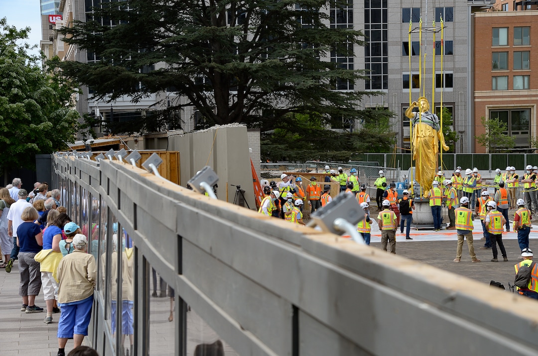 (Francisco Kjolseth  |  The Salt Lake Tribune) People gather to get a closer look of the Angel Moroni statue after it was pulled from atop the Salt Lake Temple of The Church of Jesus Christ of Latter-day Saints on Monday, May 18, 2020. The temple closed in December for seismic upgrades and sustained minor damager during the March 18, 2020, magnitude 5.7 earthquake when the trumpet held by the angel fell off and several smaller spire stones were displaced.