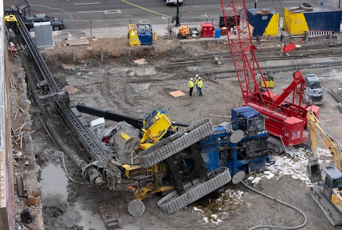 (Francisco Kjolseth | The Salt Lake Tribune) Crews survey the damage of a collapsed drill rig as seen on Wednesday, March 16, 2022, at the intersection of State Street and 200 South. The rig toppled over Tuesday night at the site of the new Astra Tower, crushing two unoccupied parked cars and sending the crane operator to the hospital in serious condition.