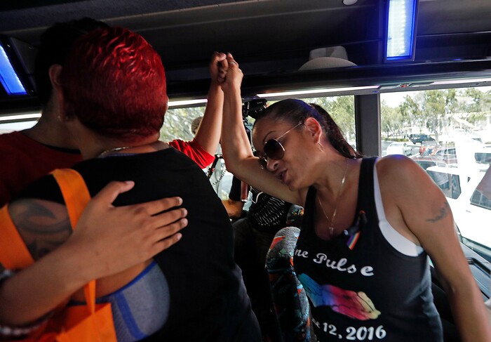 A student  from Marjory Stoneman Douglas High School hugs a survivor of the Pulse nightclub shooting after boarding a bus in Parkland, Fla., Tuesday, Feb. 20, 2018.  The students plan to hold a rally Wednesday in hopes that it will put pressure on the state's Republican-controlled Legislature to consider a sweeping package of gun-control laws, something some GOP lawmakers said Monday they would consider.  (AP Photo/Gerald Herbert)