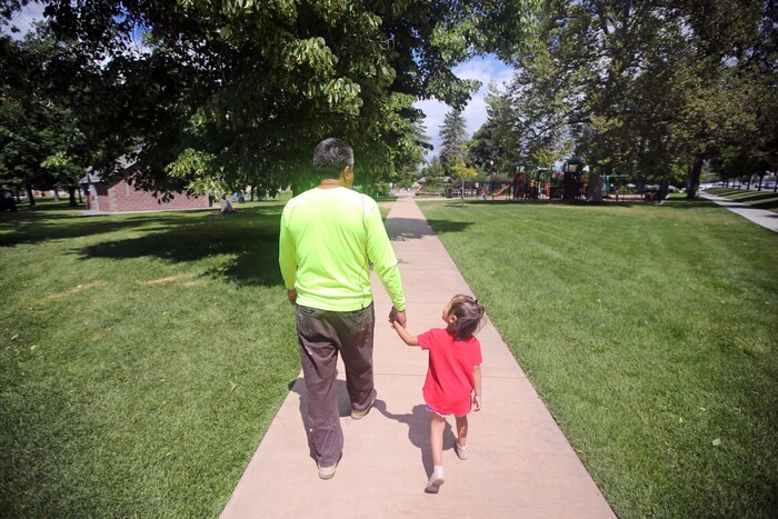 Romulo Gonzalez Rodriguez walks with his 3-year-old daughter Genesis following a interview Tuesday, June 19, 2018, in Provo, Utah. Gonzalez Rodriguez spoke about the anguish of being separated from his 3-year-old daughter, Genesis Gonzalez Lopez, for seven days in November after arriving to the U.S. port of entry in San Diego. Gonzalez Rodriguez said he fled his hometown of Champerico, Guatemala to seek asylum in the United States after he was kidnapped and extorted by captors who cut his eye out and nearly killed him. (AP Photo/Rick Bowmer)