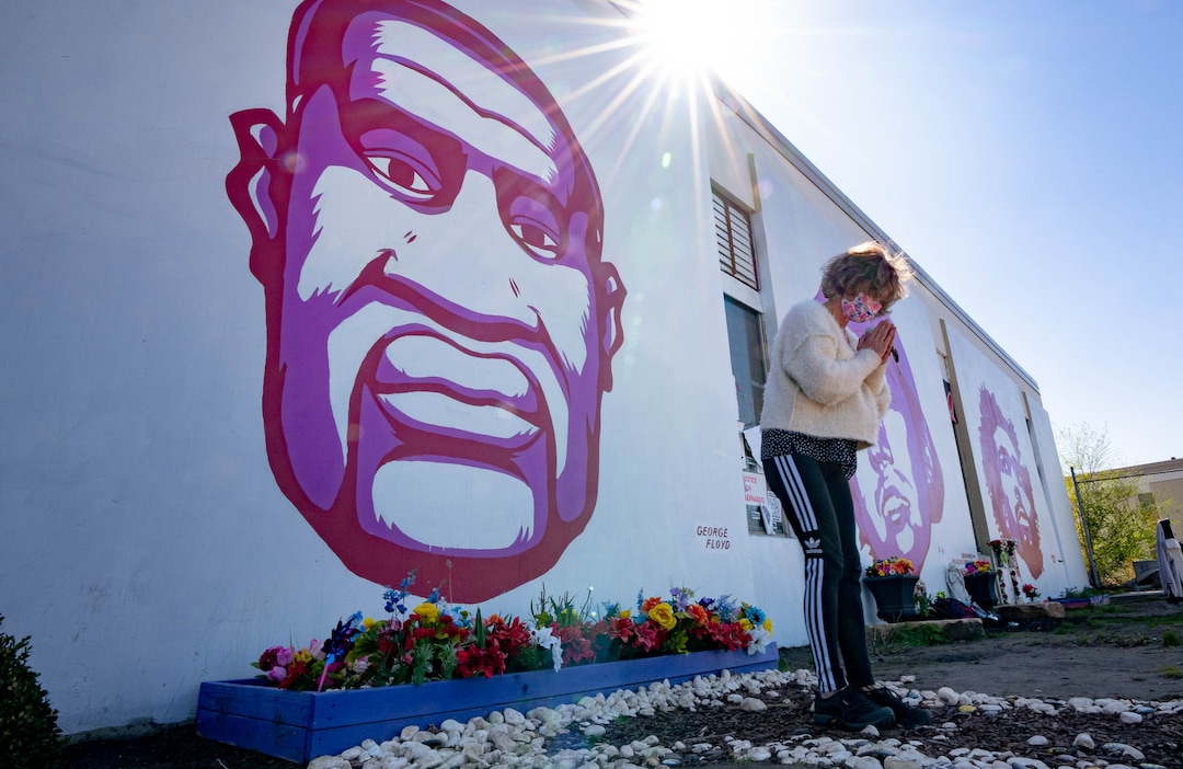 (Francisco Kjolseth  | The Salt Lake Tribune) Stephanie Merzel who is Buddhist gestures as a way to “honor” the memory of George Floyd as she stops at his mural in downtown Salt Lake City on Tuesday, April 20, 2021, following the guilty verdict on all three counts in the murder trial of former Minneapolis police Officer Derek Chauvin in the death of George Floyd.
