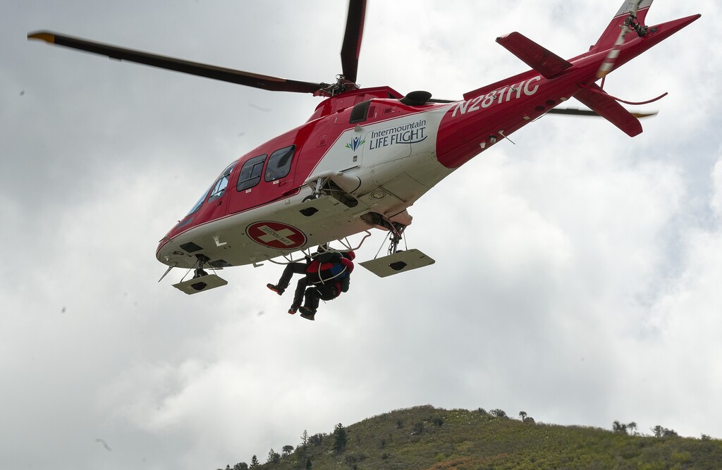 (Chris Samuels | The Salt Lake Tribune) An Intermountain LifeFlight helicopter hoists a person before landing near Hidden Valley Park in Sandy, Thursday, May 9, 2024.