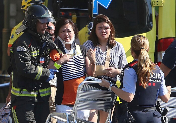 (Oriol Duran | The Associated Press) Injured people are treated in Barcelona, Spain, Thursday, Aug. 17, 2017 after a white van jumped the sidewalk in the historic Las Ramblas district, crashing into a summer crowd of residents and tourists and injuring several people, police said.