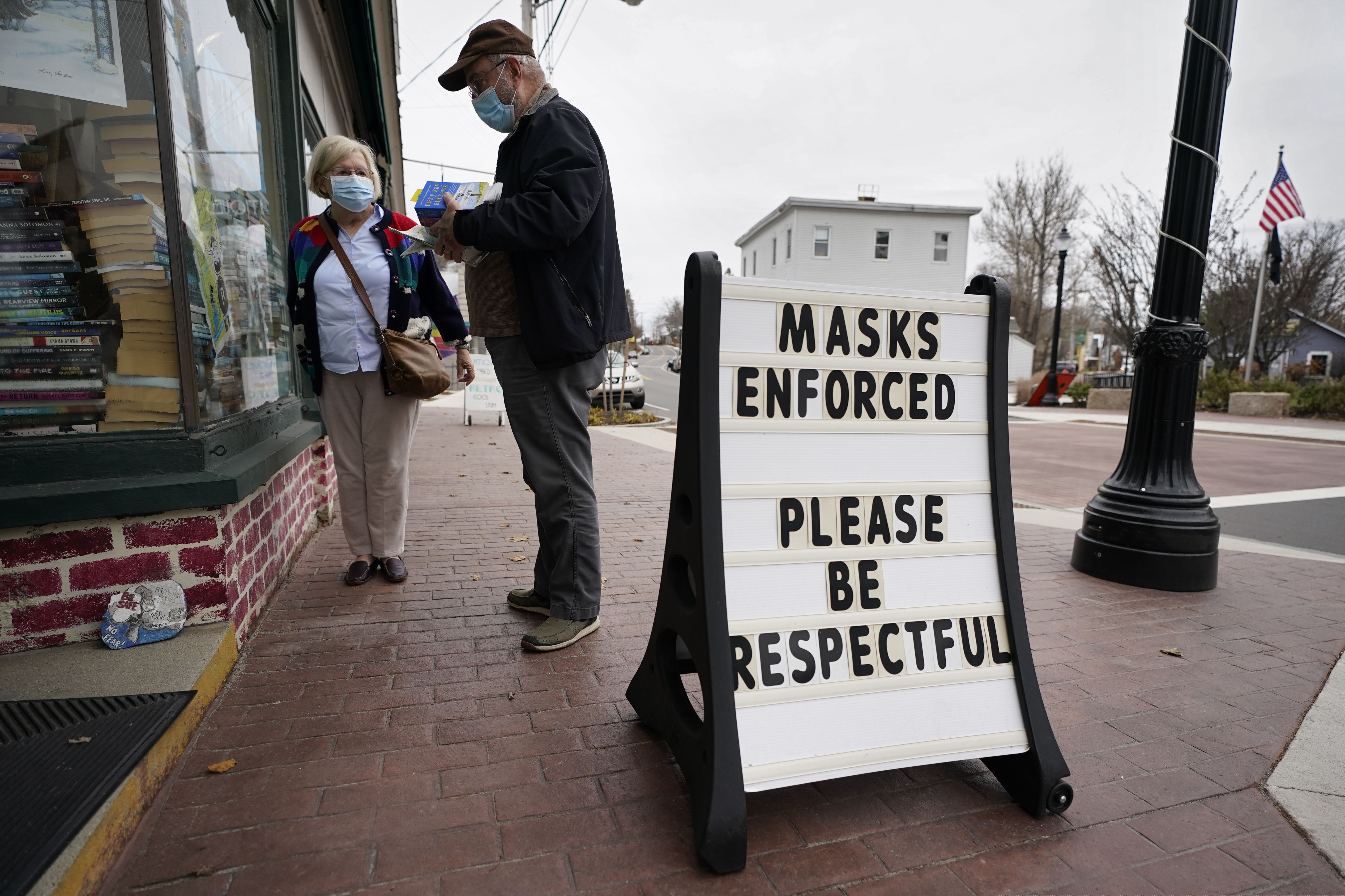 Shoppers comply with the mask regulations to help prevent the spread of the coronavirus at Bridgton Books, Friday, Nov. 13, 2020, in Bridgton, Maine. With the coronavirus coming back with a vengeance across the country and the U.S. facing a long, dark winter, governors and other elected officials are showing little appetite for reimposing the kind of lockdowns and large-scale business closings seen last spring. (AP Photo/Robert F. Bukaty)