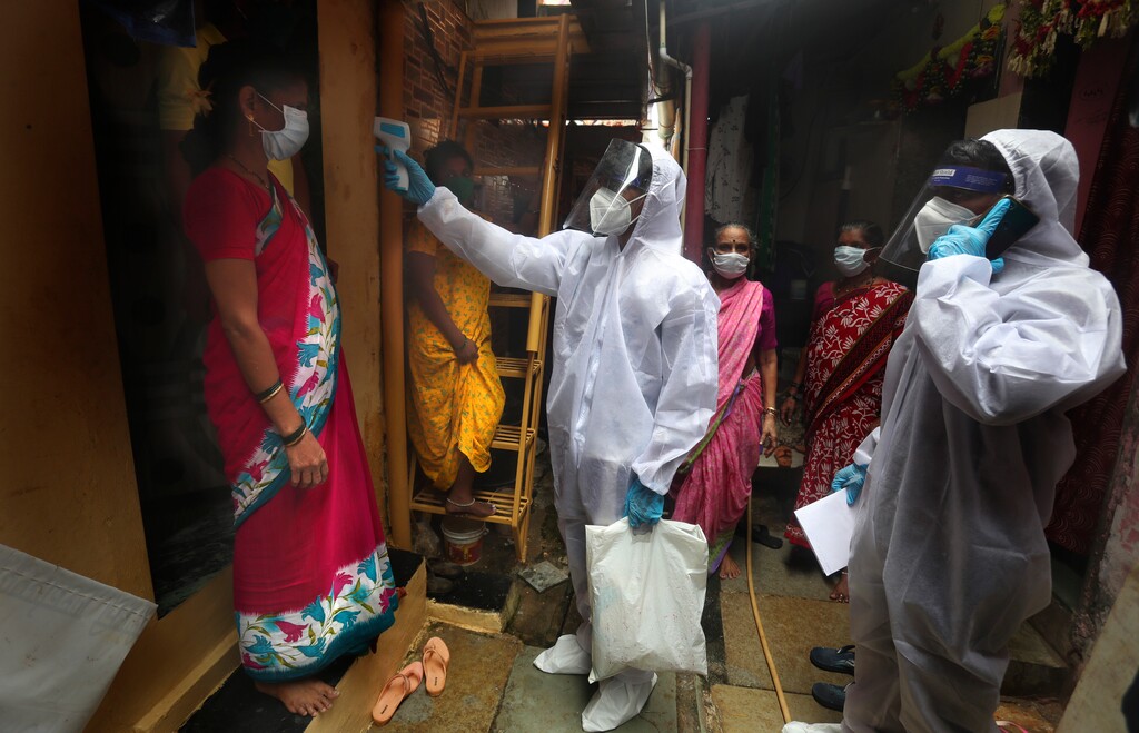 (Rafiq Maqbool | The Associated Press) A health worker checks the body temperature of a resident, as others await their turn during a free medical checkup in a slum in Mumbai, India, Sunday, June 28, 2020. India is the fourth hardest-hit country by the COVID-19 pandemic in the world after the U.S., Russia and Brazil.