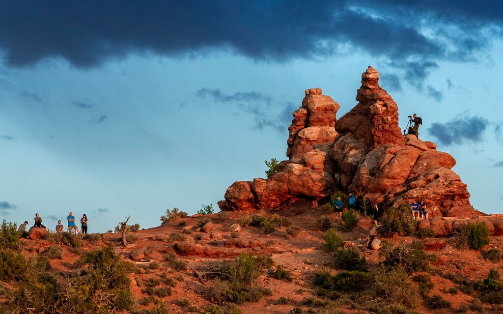 (Leah Hogsten | The Salt Lake Tribune) Visitors climb the sandstone near Turret Arch to view and photograph the sunset in Arches National Park, Monday, May 15, 2023. In April 2023, Arches National Park implemented a timed entry system to pace visitors' arrival times to alleviate overcrowding and congestion among some 1.8 million visitors a year.