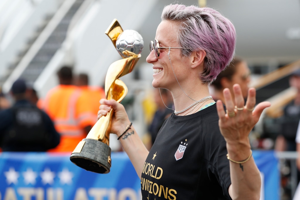 (Kathy Willens | AP Photo) United States women's soccer team member Megan Rapinoe holds the Women's World Cup trophy as she poses for the media after arriving with the rest of the team at Newark Liberty International Airport, Monday, July 8, 2019, in Newark, N.J.