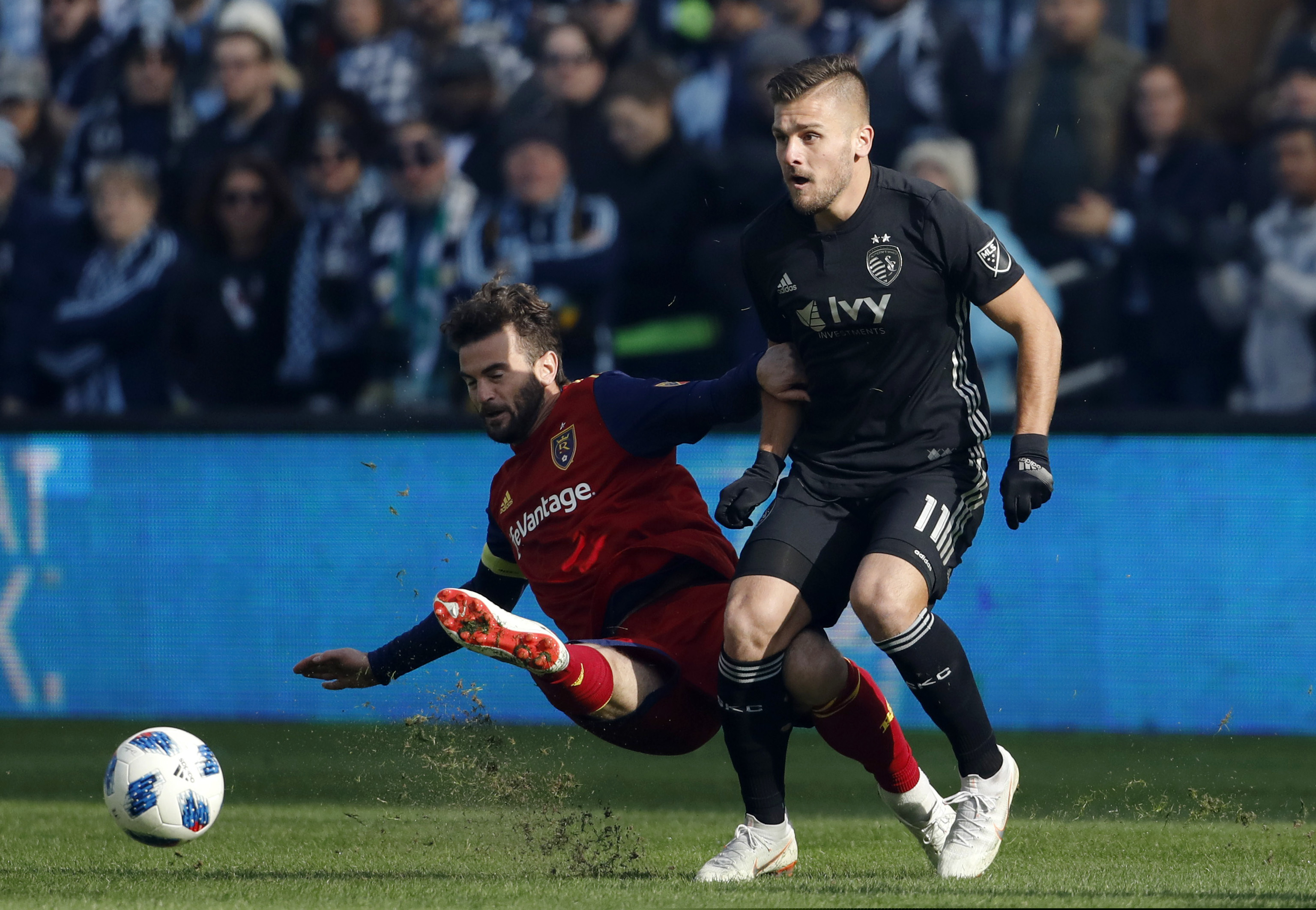 Real Salt Lake midfielder Kyle Beckerman (5) clears the ball away from Sporting Kansas City forward Diego Rubio (11) during the first half of a MLS Western Conference semifinals soccer match in Kansas City, Kan., Sunday, Nov. 11, 2018. (AP Photo/Colin E. Braley)
