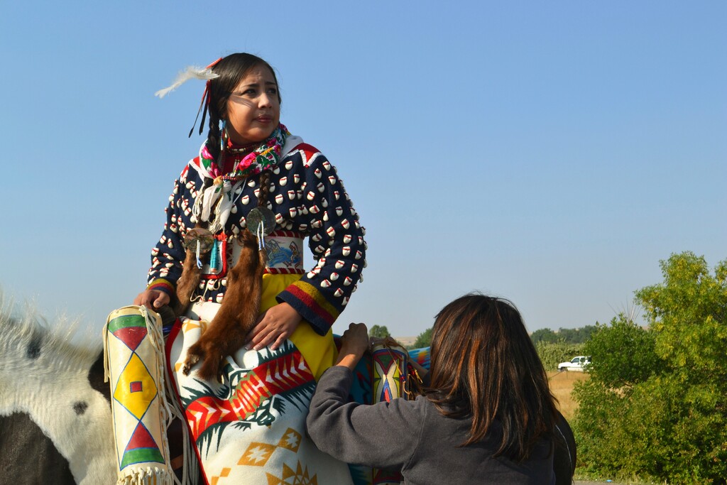 In this Friday, Aug. 18, 2017 photo, Julia Brien, left, prepares for the Crow Fair parade in Crow Agency, Mont. For the Crow Tribe, the eclipse coincides with the Parade Dance at the annual Crow Fair, marking the tribe's new year. (AP Photo/Mary Hudetz)