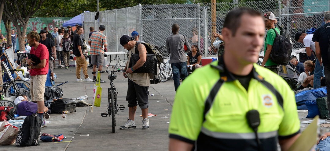 Al Hartmann  |  The Salt Lake TribuneSalt Lake City police officer Sgt. Sam Wolf talks to homeless people camped near 200 S. and 500 W. Wednesday morning July 19.   He politely wakes up dozens of homeless camped on the sidewalks, telling them that they have to break down their camps and offers advice for help and rescources.   Camping on the street is a class B misdemeanor and can now be enforced. 