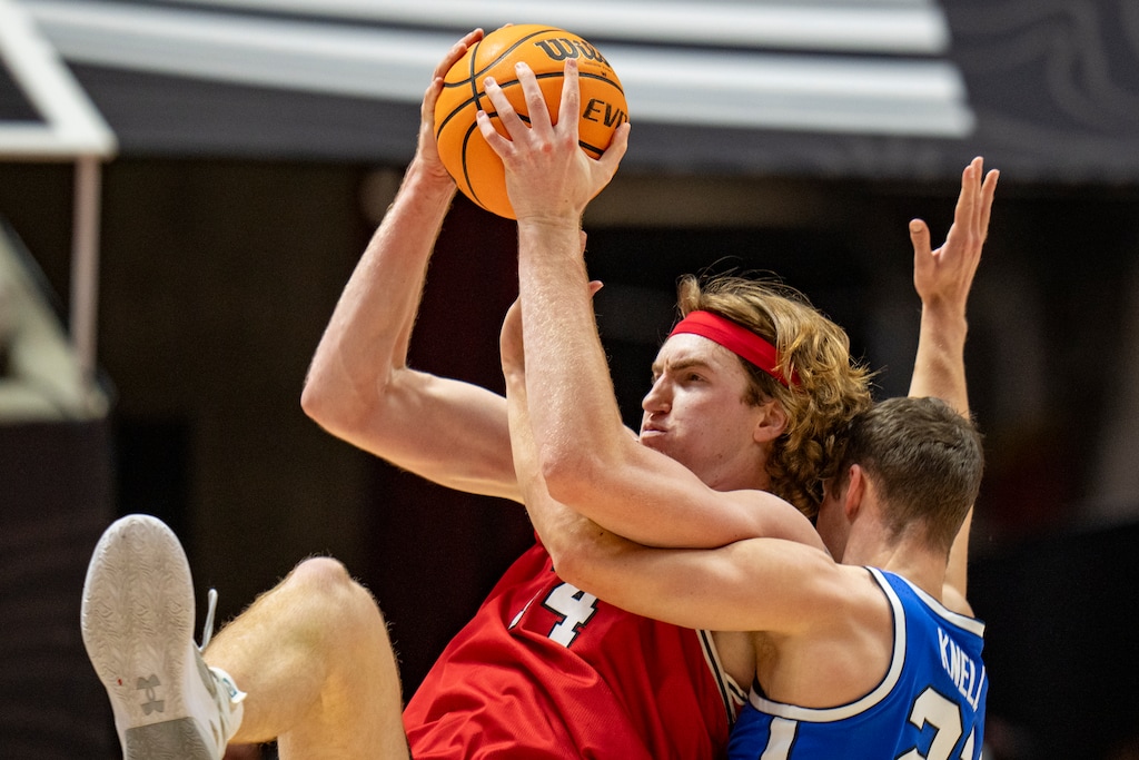 (Rick Egan | The Salt Lake Tribune) Utah Utes center Lawson Lovering (34) grabs a pass, as Brigham Young Cougars guard Trevin Knell (21), defends, in Big 12 basketball action between the Utah Utes and the Brigham Young Cougars, at the Jon M. Huntsman Center, on Saturday, Jan 18, 2025.