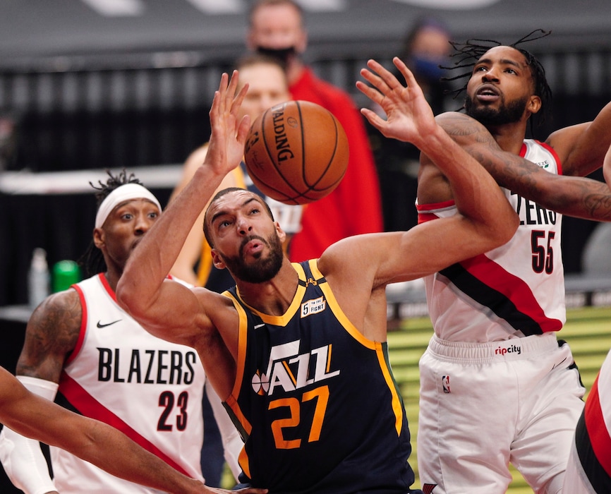 (Steve Dipaola| The Associated Press)
Portland Trail Blazers forward Derrick Jones Jr., right, and Utah Jazz center Rudy Gobert, middle, vie for a rebound as Trail Blazers forward Robert Covington, left, watches during the first half of an NBA basketball game in Portland, Ore., Wednesday, Dec. 23, 2020.