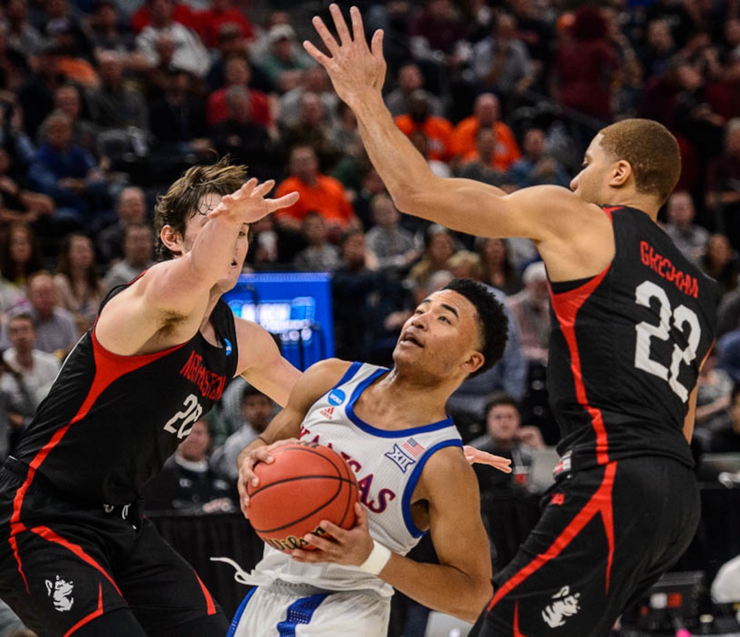 (Trent Nelson | The Salt Lake Tribune)  Kansas Jayhawks guard Devon Dotson (11) drives on Northeastern Huskies guard Bolden Brace (20) and Northeastern Huskies guard Donnell Gresham Jr. (22) as Kansas faces Northeastern in the 2019 NCAA Tournament in Salt Lake City on Thursday March 21, 2019.