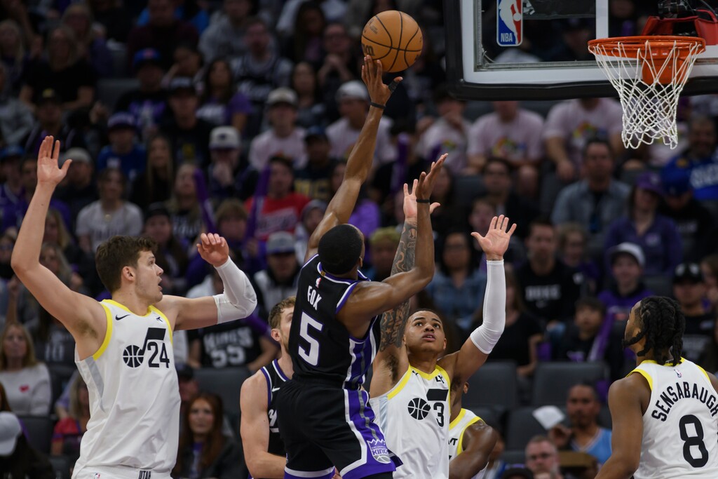 (Randall Benton | AP) Sacramento Kings guard De'Aaron Fox (5) shoots over Utah Jazz guard Keyonte George (3) during the second half of an NBA basketball game in Sacramento, Calif., Sunday, March 31, 2024. The Kings won 127-106.