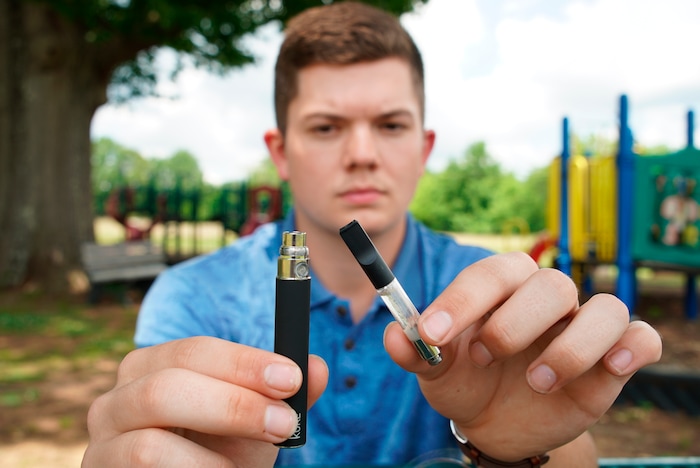 (Allen G. Breed | AP) Jay Jenkins holds a Yolo! brand CBD oil vape cartridge alongside a vape pen at a park in Ninety Six, S.C., on Wednesday, May 8, 2019. Jenkins says two hits from the vape put him in a coma and nearly killed him in 2018. Lab testing commissioned by AP showed the vape contained a synthetic marijuana compound blamed for at least 11 deaths in Europe. Jenkins was interviewed as part of an AP investigation into the dark side to the booming CBD industry, in which some people are cashing in by substituting cheap and illegal synthetic marijuana for the natural cannabis extract.