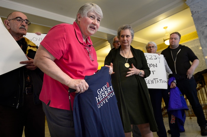 Scott Sommerdorf | The Salt Lake Tribune
Marlene Jennings, a former delegate for Gary Herbert when he ran for Governor, shows her shirt to media gathered outside Governor Gary Herbert's office. Jennings later gave back the shirt to Herbert's staff over the issue of the inland port and SB234, Thursday, March 14, 2018.