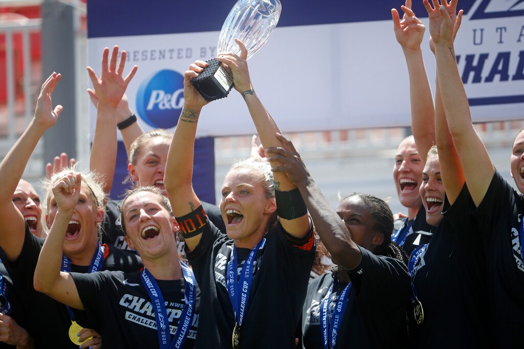 Houston Dash forward Rachel Daly holds the trophy alongside teammates as they celebrate their Challenge Cup championship win over the Chicago Red Stars, Sunday, July 26, 2020, in Sandy, Utah. (AP Photo/Rick Bowmer)