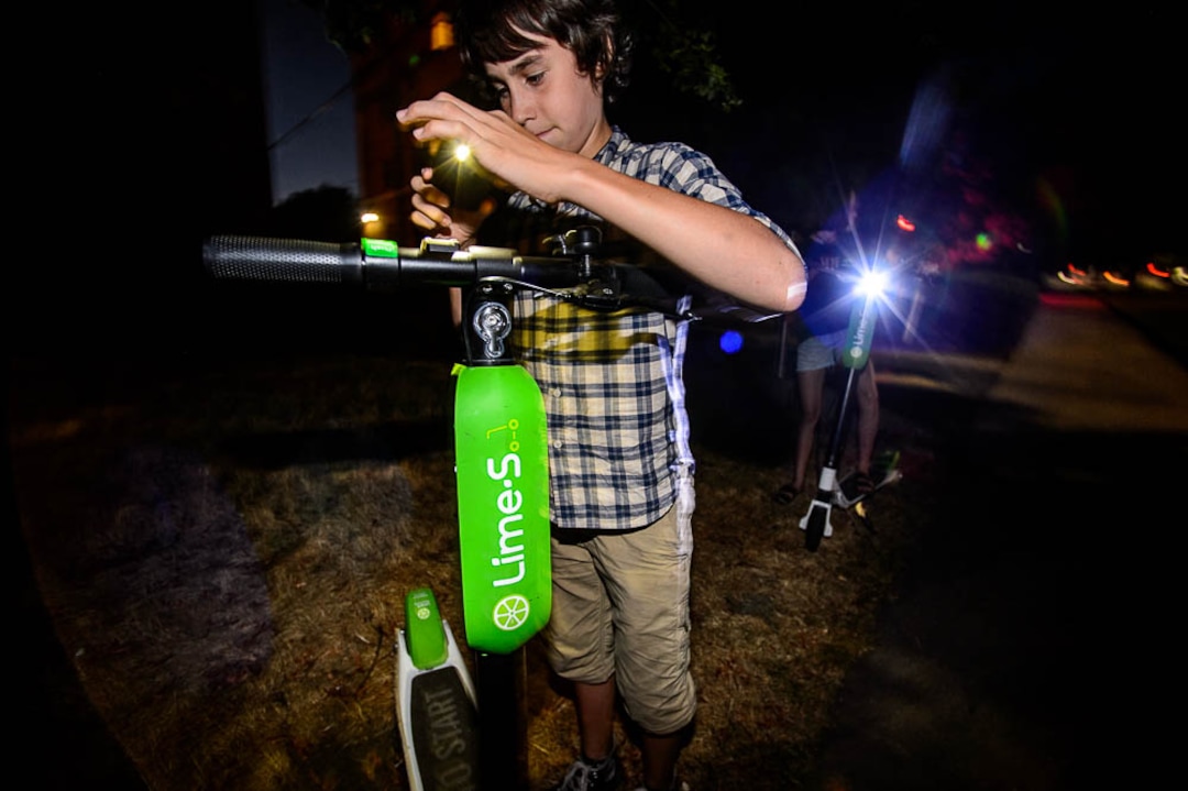 (Trent Nelson | The Salt Lake Tribune) Chase Hein captures a scooter in Salt Lake City Tuesday Aug. 7, 2018. His mother, Jenn Hein, works as a "Bird charger" on the side to make some extra cash, picking up and charging electric scooters overnight and returning them to the city streets in the early morning.