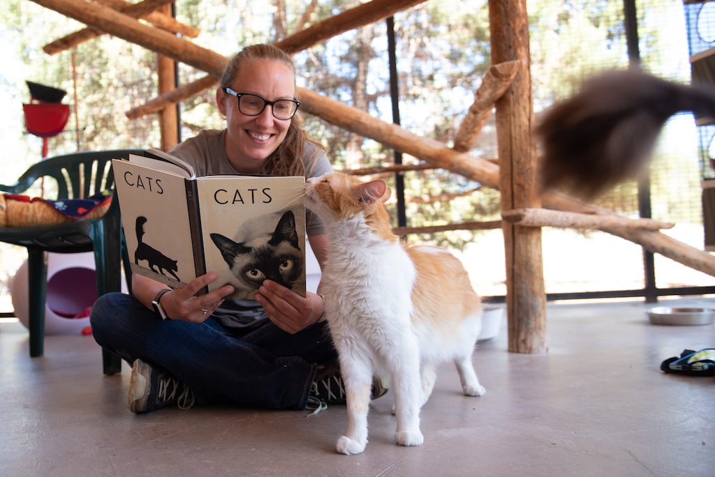 (Molly Wald) Cat World director Amy Kohlbecker reading to a feline leukemia positive cat named Ken at Best Friends Animal Sanctuary in Kanab, Utah.