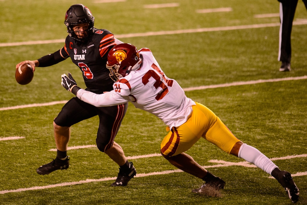 (Trent Nelson | The Salt Lake Tribune) Utah Utes quarterback Jake Bentley (8) tries to get the ball away as USC Trojans linebacker Hunter Echols (31) reaches out, as the Utah Utes host the USC Trojans, NCAA football at Rice-Eccles Stadium in Salt Lake City on Saturday, Nov. 21, 2020.