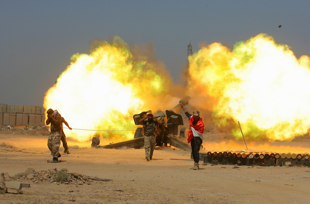 (Anmar Khalil | AP file photo) In this May 29, 2016 file photo, Iraqi security forces and allied Popular Mobilization forces fire artillery during fight against Islamic State militants in Fallujah, Iraq. When U.S. Secretary of State Mike Pompeo sat down with Iraqi officials in Baghdad earlier this month as tensions were mounting between the U.S. and Iran, he delivered a nuanced message: If you're not going to stand with us, stand aside.