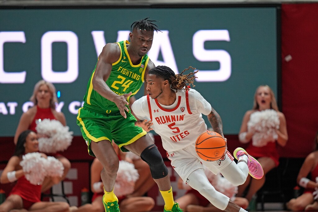 Utah guard Deivon Smith (5) drives around Oregon forward Mahamadou Diawara (24) during the second half of an NCAA college basketball game Sunday, Jan. 21, 2024, in Salt Lake City. (AP Photo/Rick Bowmer)