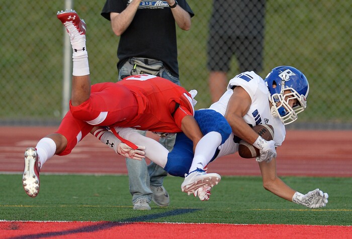 (Francisco Kjolseth  |  The Salt Lake Tribune)  Avi Parikh of Bingham runs in his team's second touchdown while pressured by Mekelee Gautavai of East in the first half of their game at East on Friday, Aug. 24, 2018.