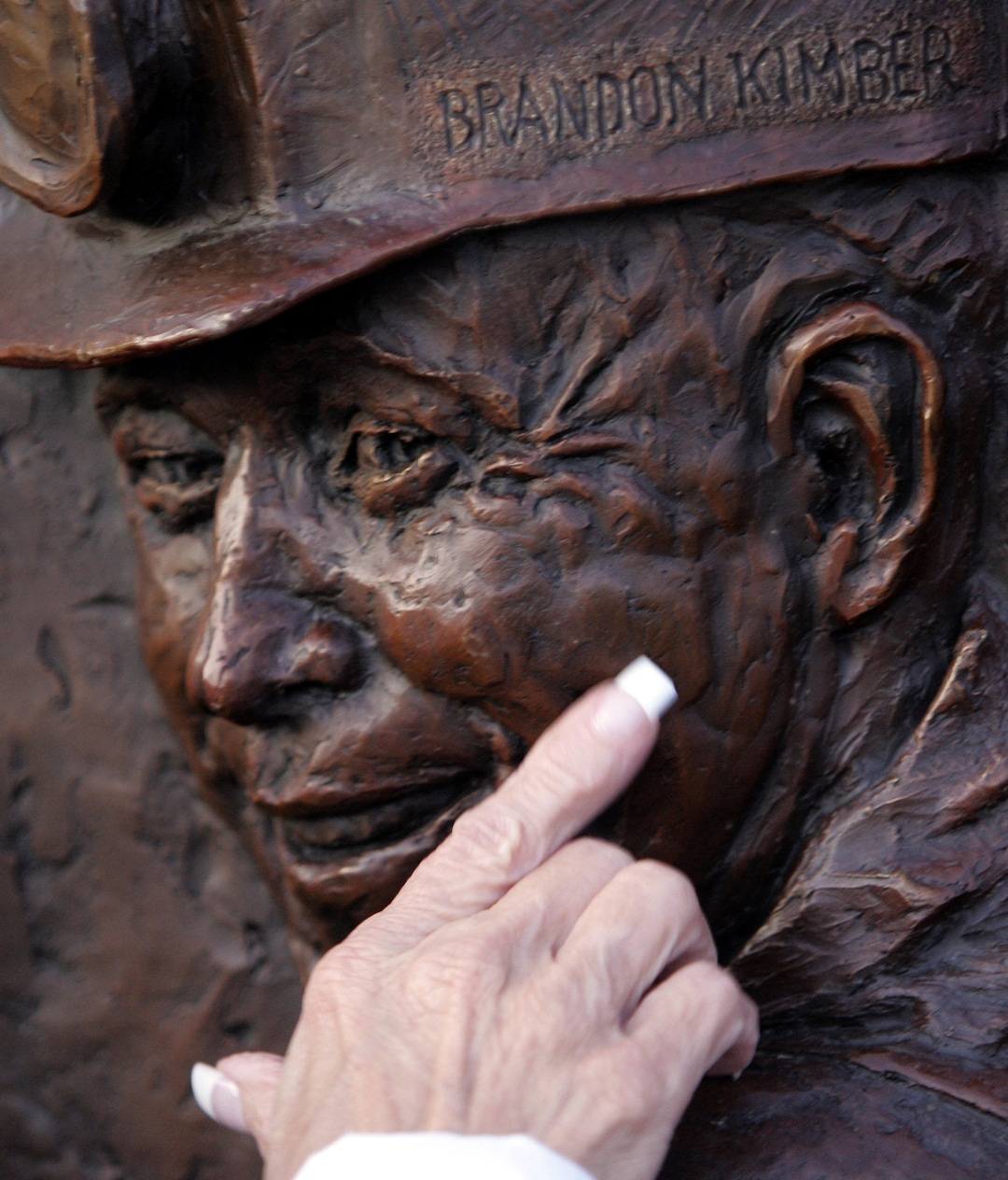 (Tribune File Photo)  Brandon Kimber's former mother-in-law, Margie Burge, touches his likeness at the unveiling of the Crandall Canyon Memorial on Sept. 14, 2008 in Huntington. Hundreds of family and friends turned out for the unveiling of the monument to the nine men who died in the two-pronged disaster in August of 2007.