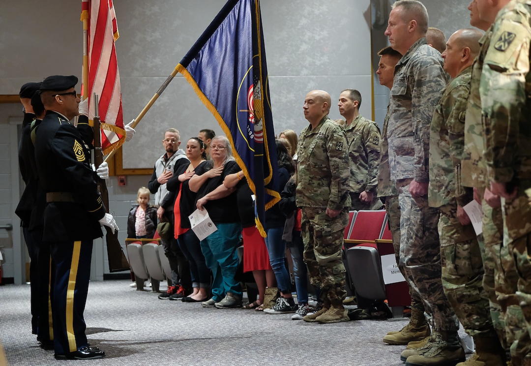 (Francisco Kjolseth  |  The Salt Lake Tribune)  The colors are posted during the start of departure ceremonies for the 141st Military Intelligence Battalion at Utah National Guard headquarters in Draper on Monday, March 19, 2018. Chaplain Maj. Gene Whitmore offered the deployment prayer ceremony for soldiers heading to Kuwait. 