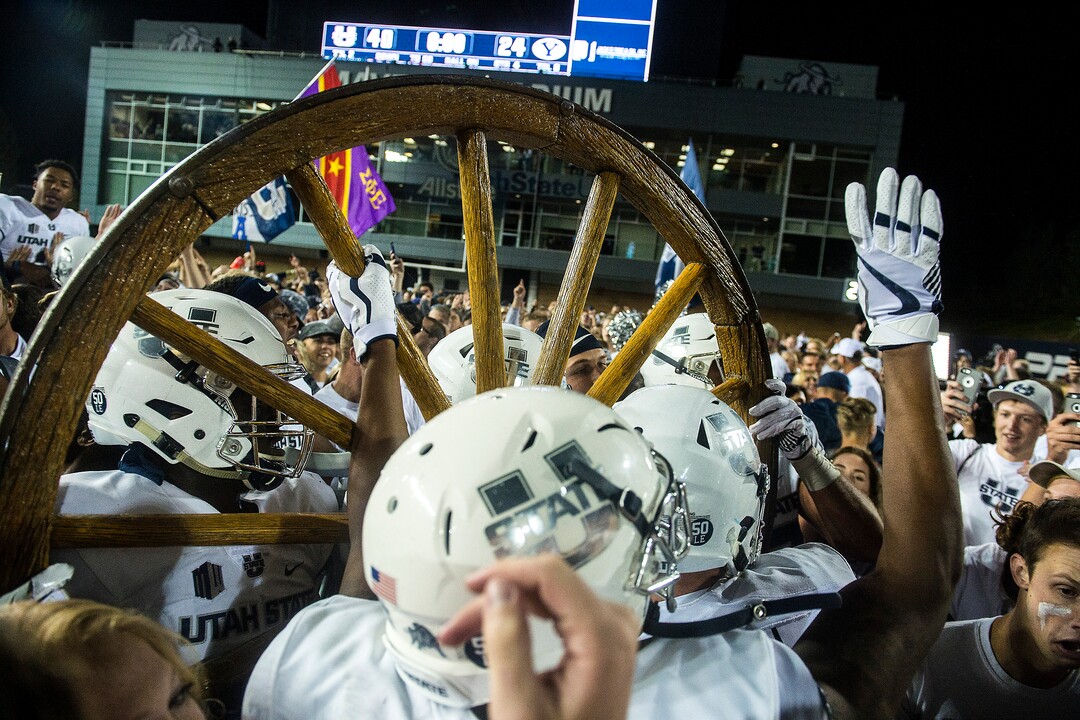 (Chris Detrick  |  The Salt Lake Tribune)  Utah State Aggies  football players and students celebrate with the Old Wagon Wheel after the game at Merlin Olsen Field at Maverik Stadium Friday, September 29, 2017. Utah State Aggies defeated Brigham Young Cougars 40-24.