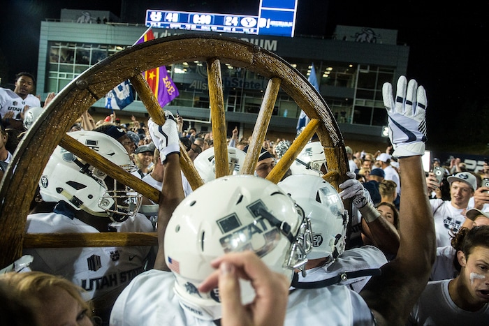 (Chris Detrick  |  The Salt Lake Tribune)  Utah State Aggies  football players and students celebrate with the Old Wagon Wheel after the game at Merlin Olsen Field at Maverik Stadium Friday, September 29, 2017. Utah State Aggies defeated Brigham Young Cougars 40-24.