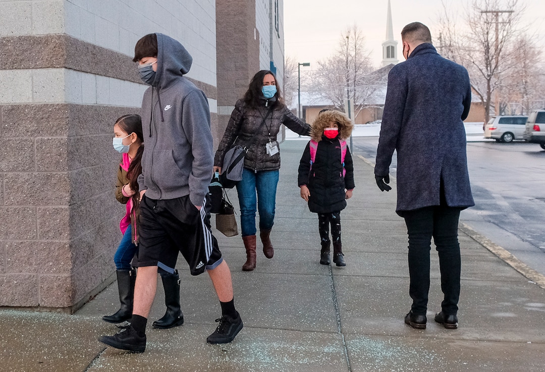 (Leah Hogsten | The Salt Lake Tribune) Escalante Elementary first grader Fatima Brito, 7, is walked to school by her brother Cesar Brito, 15,  in Salt Lake City, January, 25, 2021. Salt Lake City School District reopened all of the district's elementary schools to in-person learning on Monday. It is the first time students in kindergarten through sixth grade are back in the classroom for a full day of school since they first closed for the pandemic in March 2020.