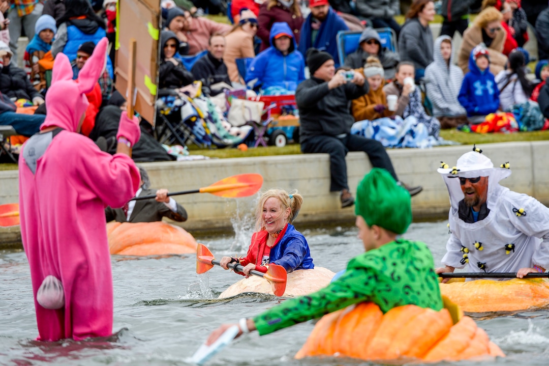 (Leah Hogsten  |  The Salt Lake Tribune) Pumpkin regatta competitor Lisa Radke, center, comes in second place during the annual Giant Pumpkin Regatta trophy race, October 19, 2019 on Oquirrh Lake in Daybreak, South Jordan.