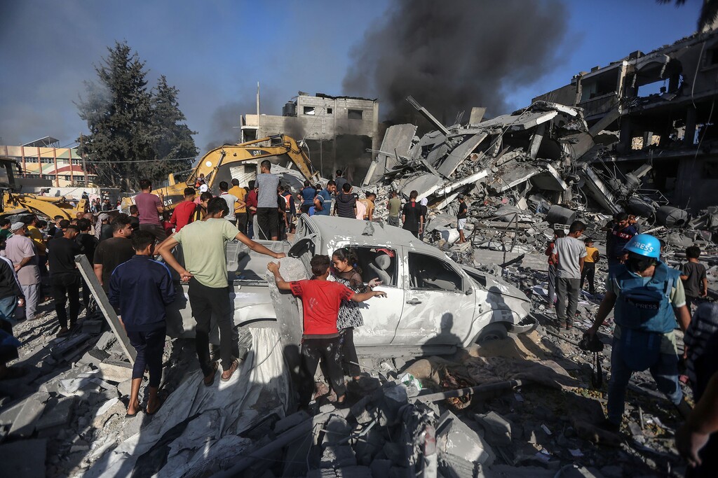Palestinians look at the site of  Israeli air strike in Khan Younis, in the Southern Gaza Strip, on Nov. 7, 2023. (Yousef Masoud for The New York Times)